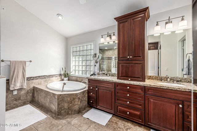bathroom with a sink, lofted ceiling, a stall shower, and a garden tub