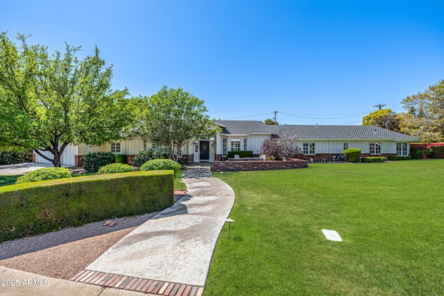 ranch-style home featuring board and batten siding and a front lawn