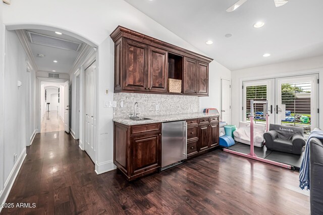 kitchen with dark wood-style flooring, refrigerator, vaulted ceiling, visible vents, and a sink