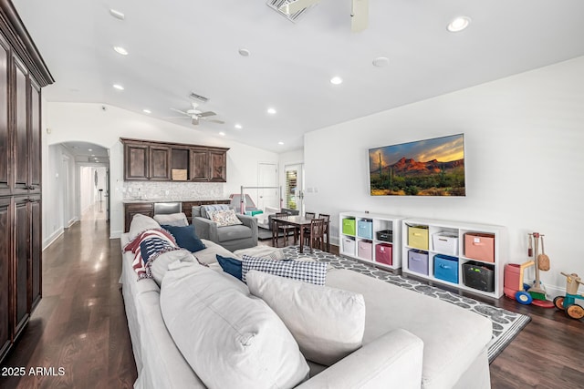 living area featuring dark wood-type flooring, arched walkways, a ceiling fan, vaulted ceiling, and recessed lighting