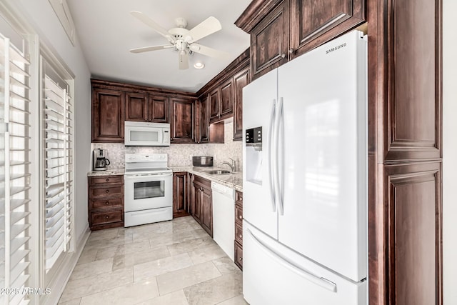 kitchen featuring a sink, a ceiling fan, white appliances, dark brown cabinetry, and backsplash