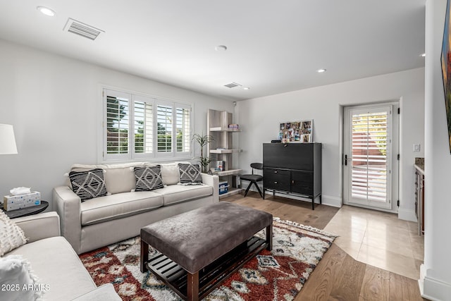 living room with wood finished floors, baseboards, visible vents, and recessed lighting