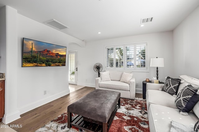 living area featuring wood finished floors, baseboards, visible vents, and recessed lighting