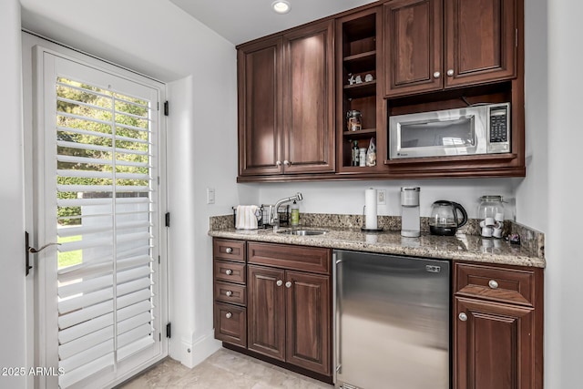 bar featuring light tile patterned flooring, indoor wet bar, a sink, and appliances with stainless steel finishes