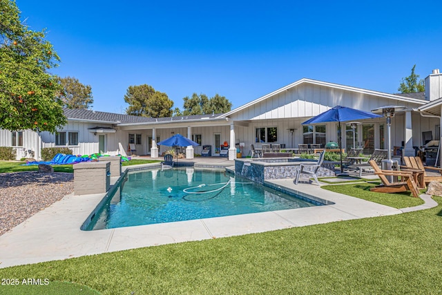 pool featuring a patio area and a lawn