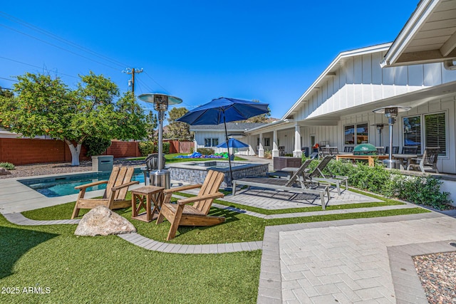 view of yard with a patio area, a fenced backyard, and a pool with connected hot tub