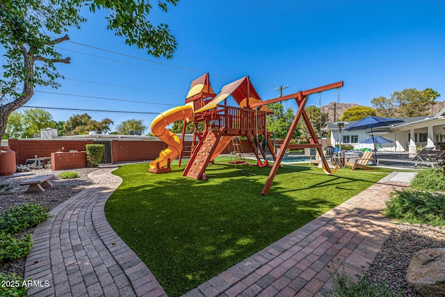 view of play area featuring a mountain view, fence, and a lawn