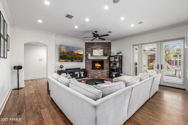 living area with recessed lighting, arched walkways, ornamental molding, and a ceiling fan
