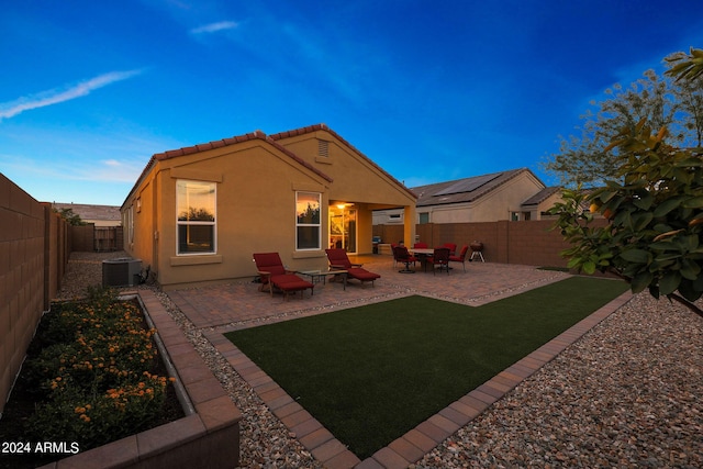 rear view of house with a patio, central AC unit, a fenced backyard, a tile roof, and stucco siding