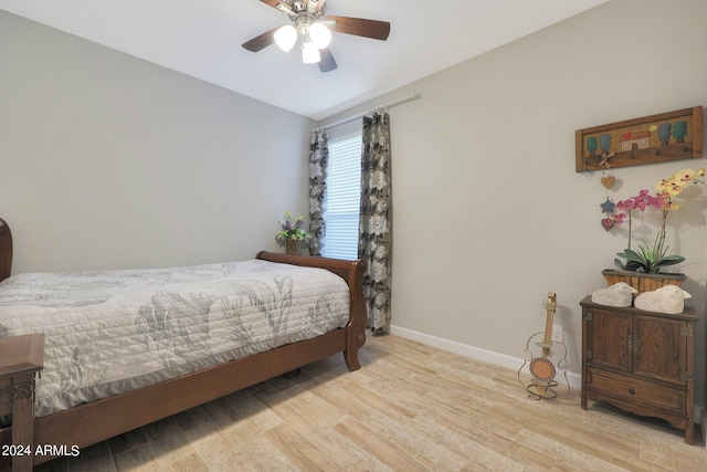 bedroom featuring a ceiling fan, baseboards, and wood finished floors