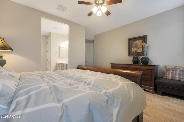 bedroom featuring light wood-style floors, visible vents, ceiling fan, and ensuite bathroom