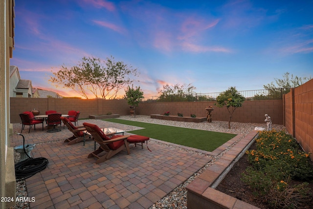 patio terrace at dusk with a fenced backyard