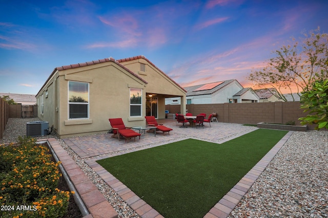 rear view of property featuring central AC unit, a fenced backyard, a tiled roof, a patio area, and stucco siding