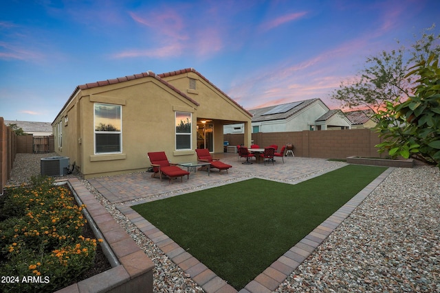 rear view of property with a patio, central AC unit, a fenced backyard, a tiled roof, and stucco siding