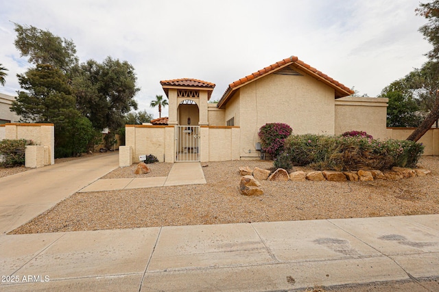 5120 E Janice Way, Scottsdale, AZ 85254 - mediterranean / spanish-style home featuring a gate, a tile roof, a fenced front yard, and stucco siding