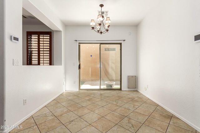 tiled spare room with a wealth of natural light and a chandelier