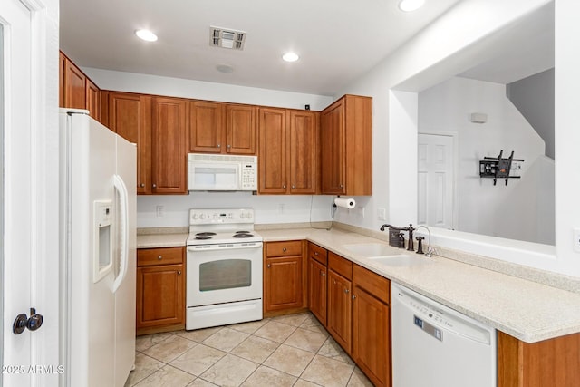 kitchen with sink, light tile patterned floors, and white appliances