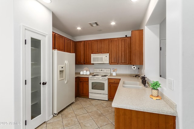 kitchen featuring light tile patterned flooring, white appliances, and sink