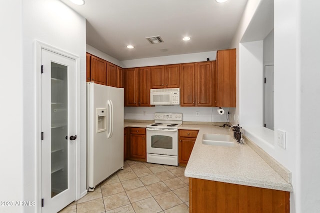 kitchen featuring sink, light tile patterned floors, and white appliances