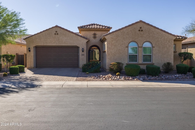 mediterranean / spanish home with a garage