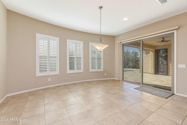 unfurnished dining area with light tile patterned floors and ceiling fan