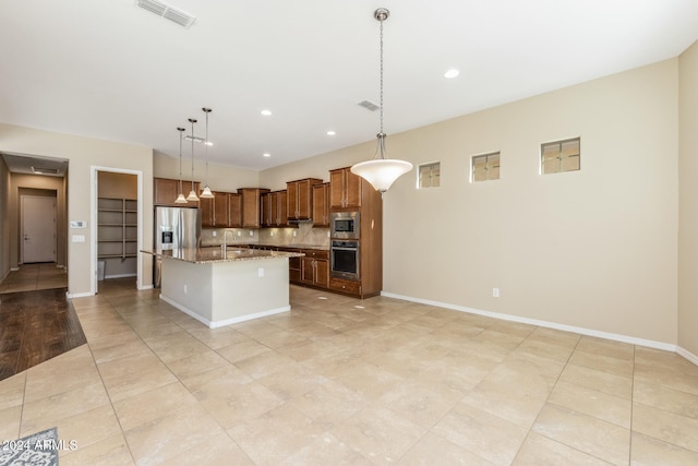 kitchen with backsplash, a kitchen island with sink, hanging light fixtures, light stone counters, and stainless steel appliances