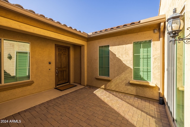 view of exterior entry with a patio