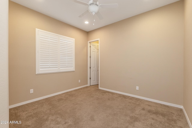 unfurnished room featuring light colored carpet and ceiling fan