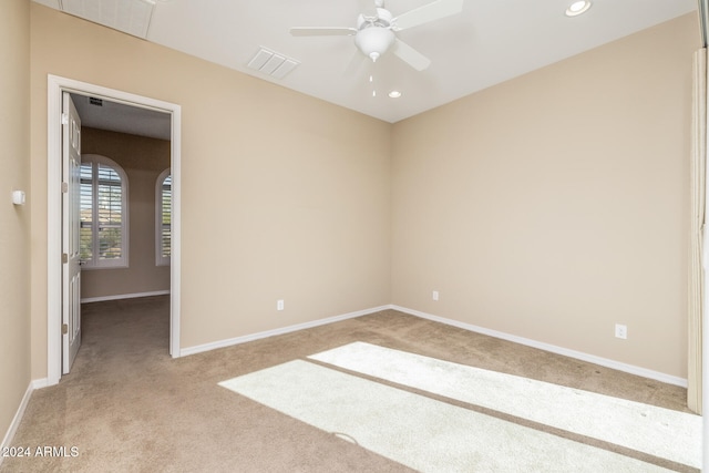 unfurnished room featuring ceiling fan and light colored carpet