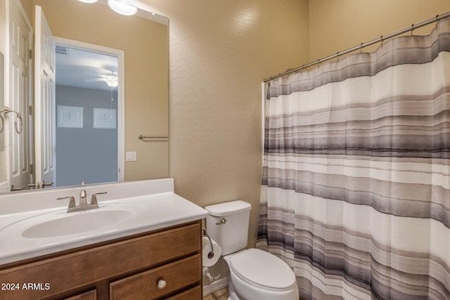 bathroom with a shower with curtain, vanity, ceiling fan, and toilet