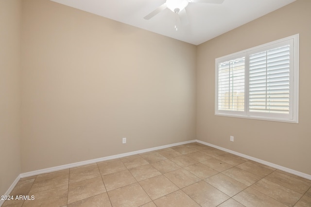 empty room with ceiling fan and light tile patterned floors