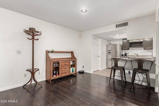 kitchen featuring a kitchen breakfast bar, high quality fridge, sink, and kitchen peninsula