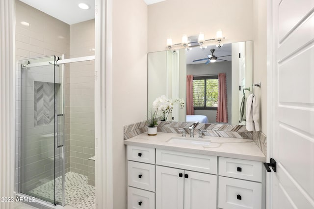 ensuite bathroom with ensuite bathroom, a shower stall, vanity, and a ceiling fan