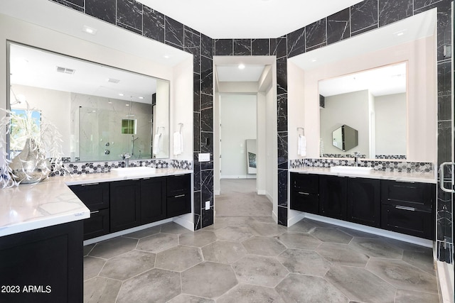 bathroom featuring tile walls, visible vents, and a sink