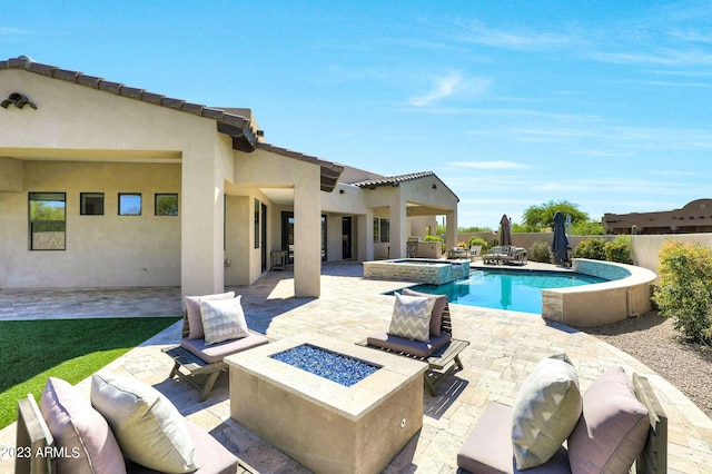 view of pool featuring a pool with connected hot tub, a patio area, fence, and a fire pit