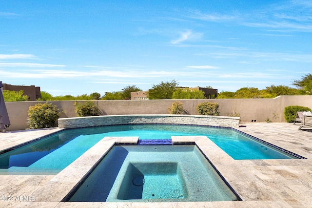 view of pool with a pool with connected hot tub, a fenced backyard, and a patio