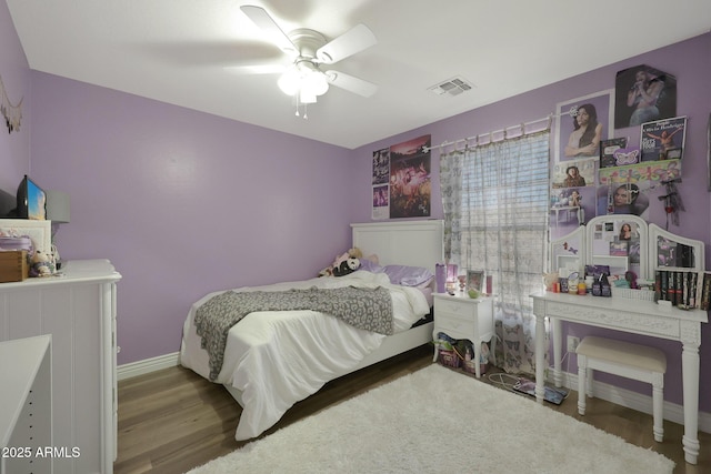 bedroom with baseboards, visible vents, a ceiling fan, and wood finished floors