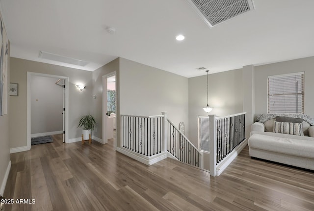 corridor featuring recessed lighting, wood finished floors, an upstairs landing, visible vents, and baseboards