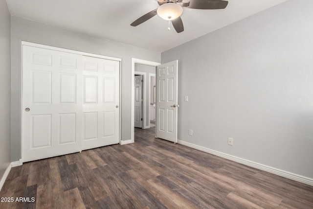 unfurnished bedroom with baseboards, dark wood-type flooring, a closet, and a ceiling fan