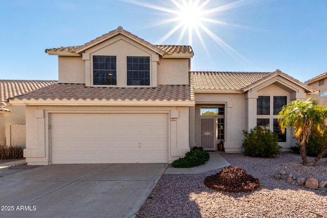 mediterranean / spanish-style house with driveway, a tile roof, stucco siding, and an attached garage
