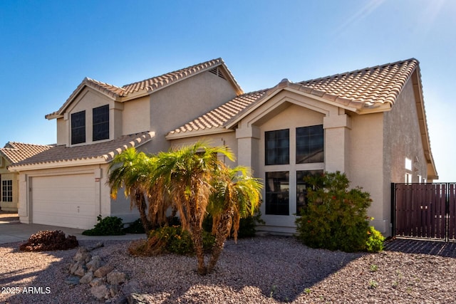 mediterranean / spanish-style home with stucco siding, an attached garage, a tile roof, and driveway