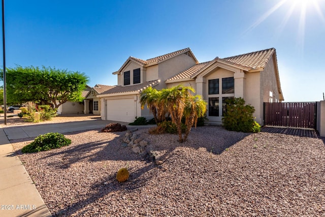 mediterranean / spanish house with driveway, stucco siding, a tiled roof, and a garage