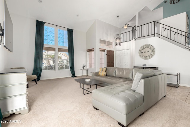 carpeted living room featuring high vaulted ceiling, a ceiling fan, and baseboards