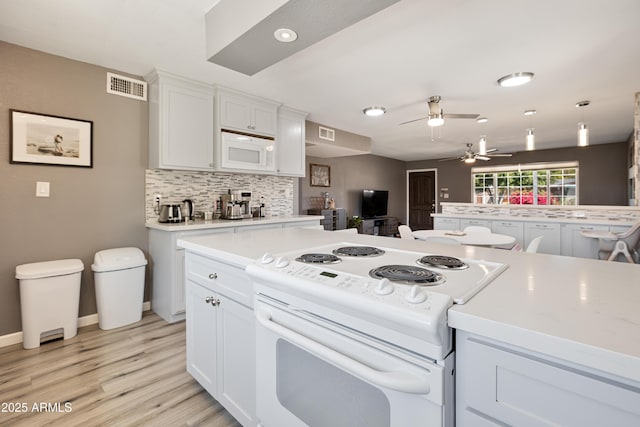 kitchen featuring a ceiling fan, light countertops, white appliances, and visible vents