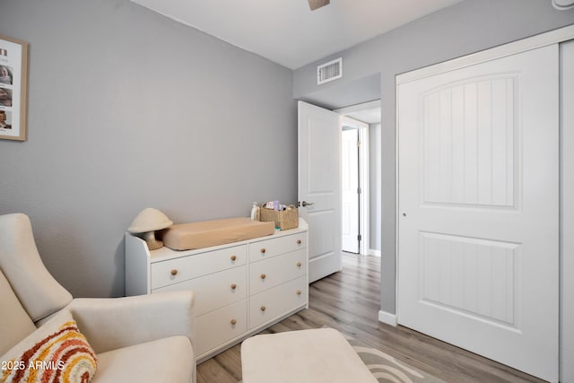 sitting room with visible vents, light wood-type flooring, and baseboards