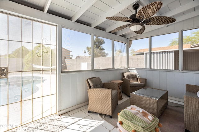 sunroom / solarium featuring a ceiling fan and beam ceiling