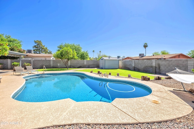 view of swimming pool featuring a lawn, a fenced backyard, a patio, a storage unit, and a fenced in pool