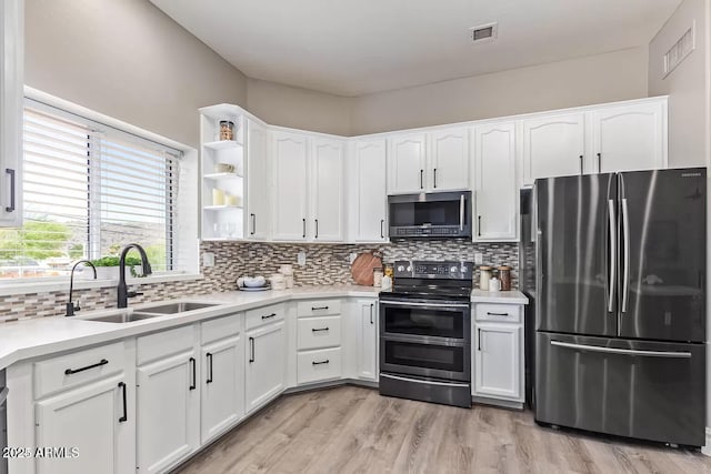 kitchen featuring a sink, visible vents, appliances with stainless steel finishes, and white cabinetry