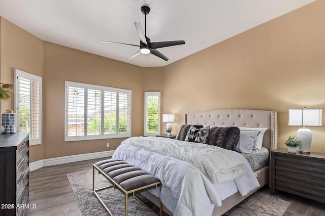 bedroom featuring baseboards, ceiling fan, and dark wood-type flooring