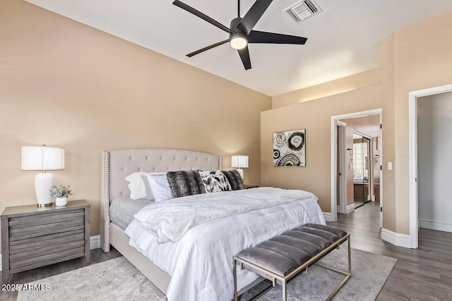 bedroom with baseboards, ceiling fan, visible vents, and wood finished floors